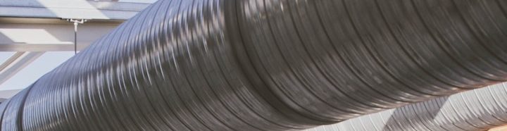 Dunkle, wellenförmige Lüftungsrohre in einem modernen Raum.