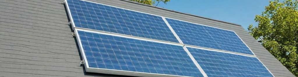 Solarmodule auf einem Dach mit grüner Umgebung.